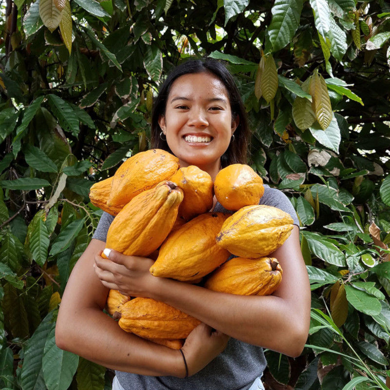 Talyssa cradleing a harvest of cacao beans