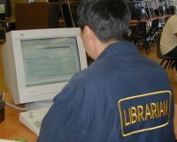 Photo of me at the Reference Desk, wearing a jacket
with the word LIBRARIAN embroidered across the back.