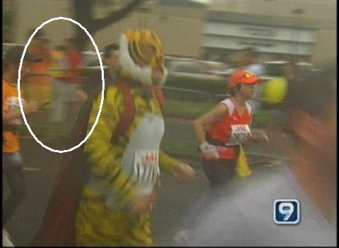 [TV image of marathon course, with me in the background]