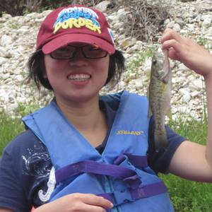 Qingman Chen holds up her first Guadalupe Bass