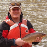 Tyler Ferguson holds the only radio-tagged Robust Redhorse captured during the study